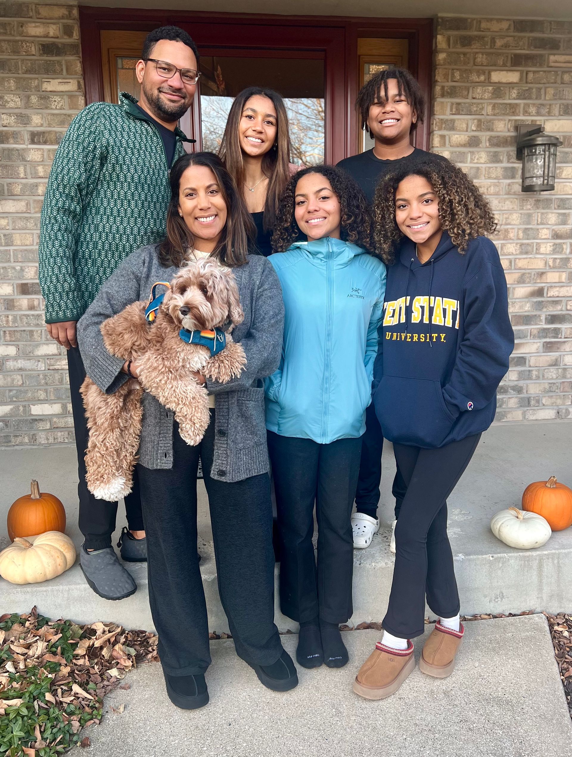 beau mitcham and his family is posing for a picture in front of a brick house.