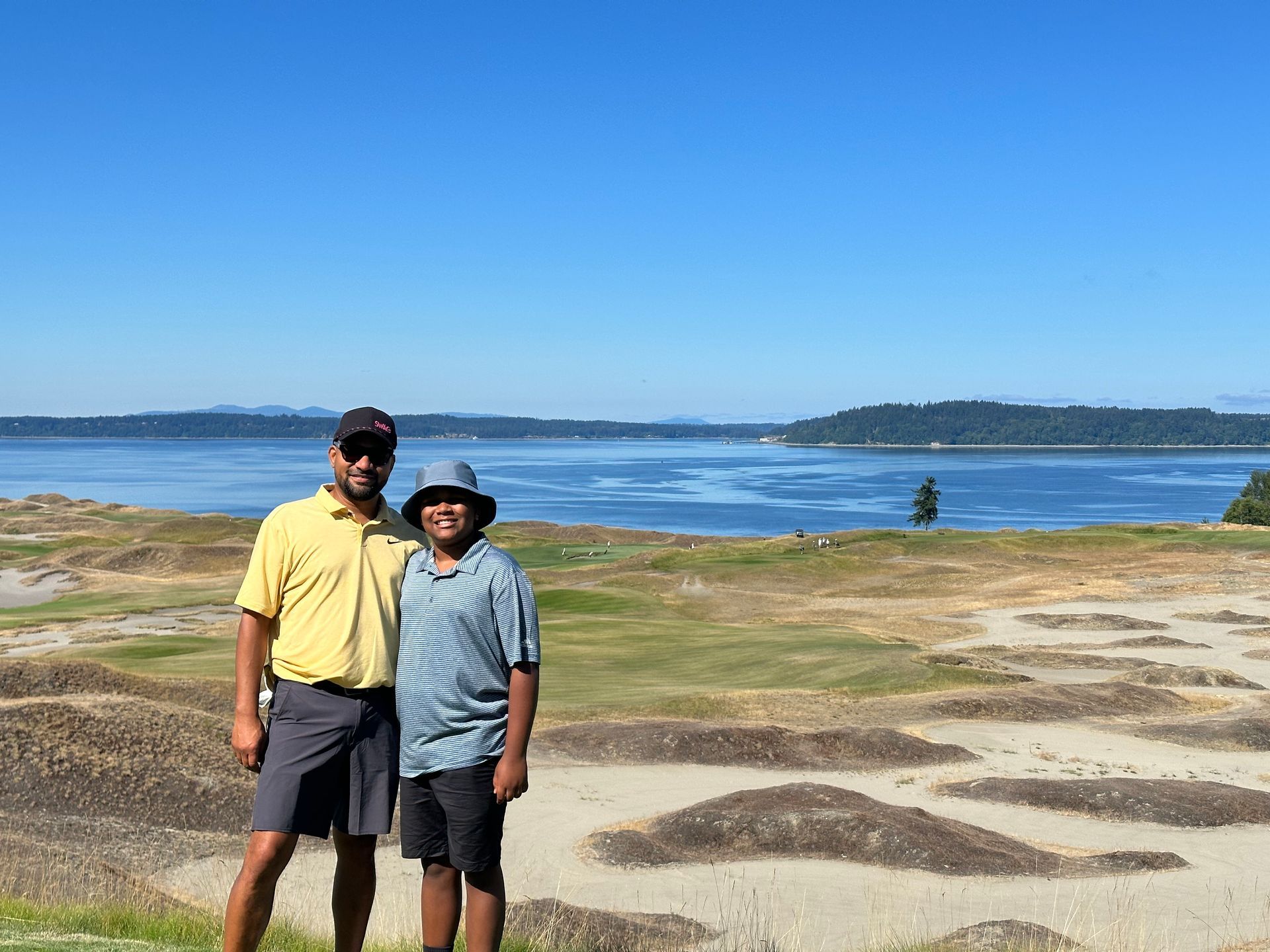 beau mitcham and a boy are posing for a picture in front of a body of water.