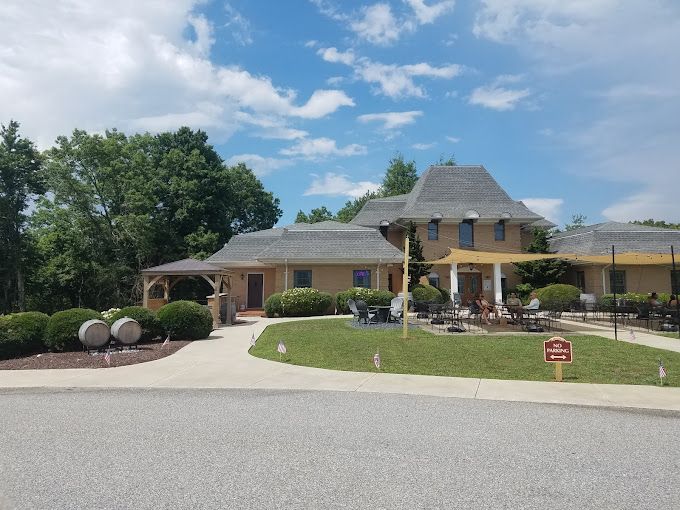 a large house with a lot of tables and chairs in front of it .