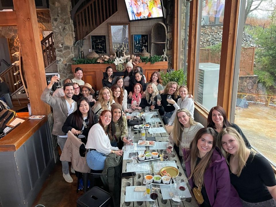 A group of people are sitting at a long table in a restaurant.