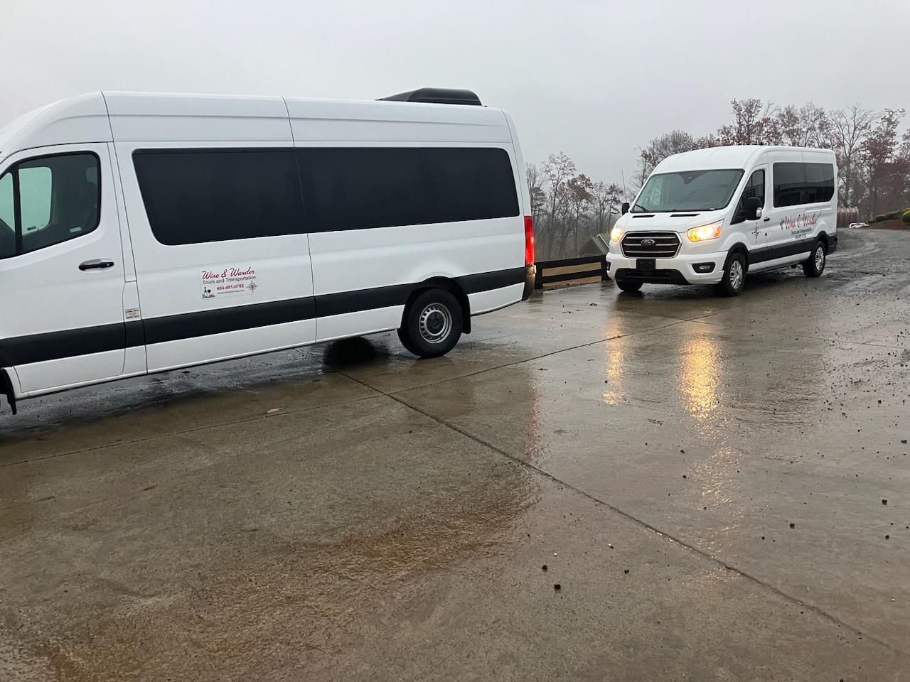Two white vans are parked next to each other in a parking lot.