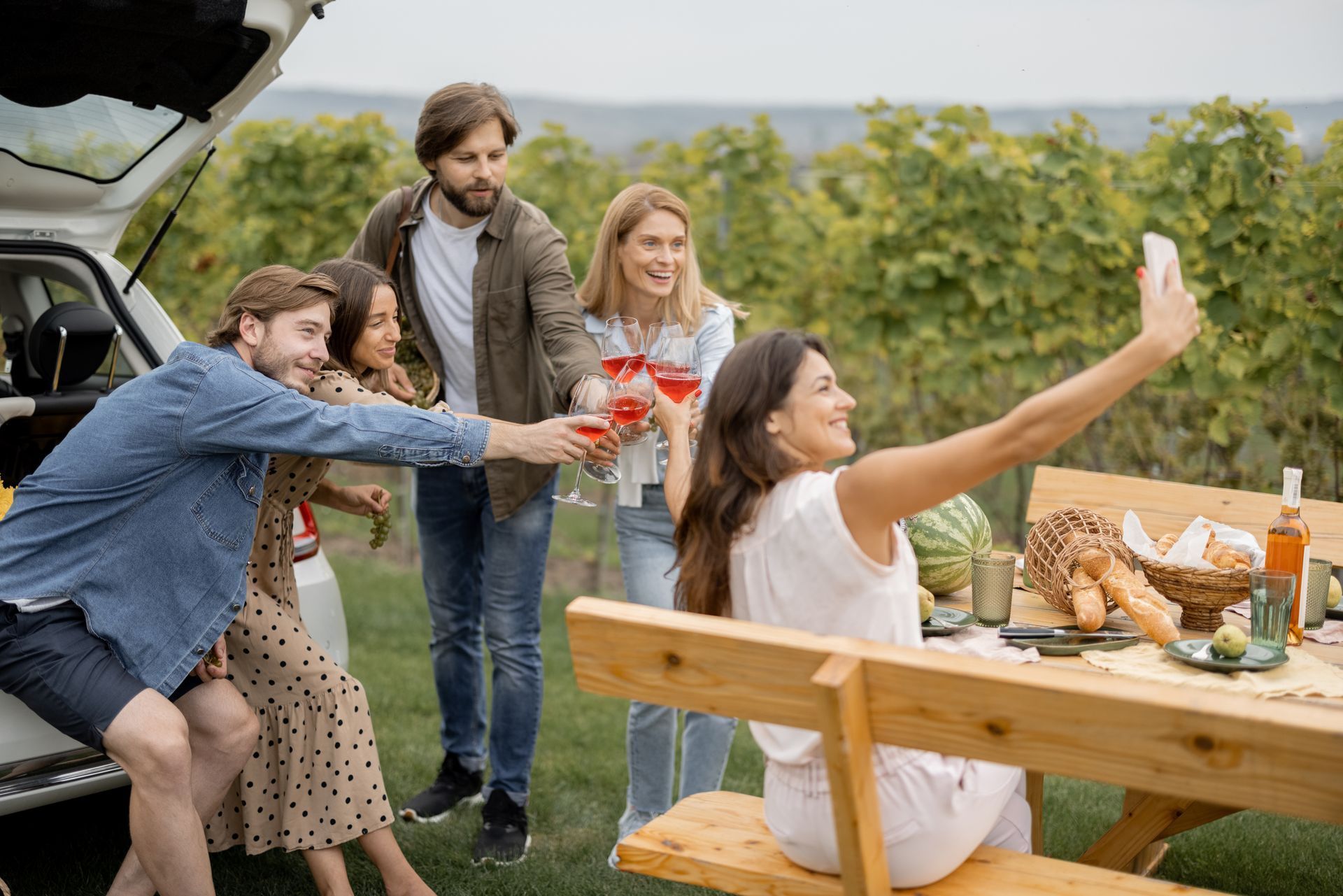A group of people are having a picnic and taking a selfie.