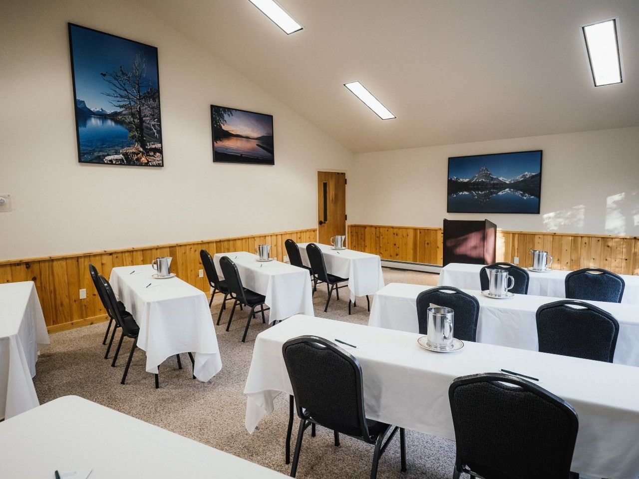 There are many tables and chairs in the room.