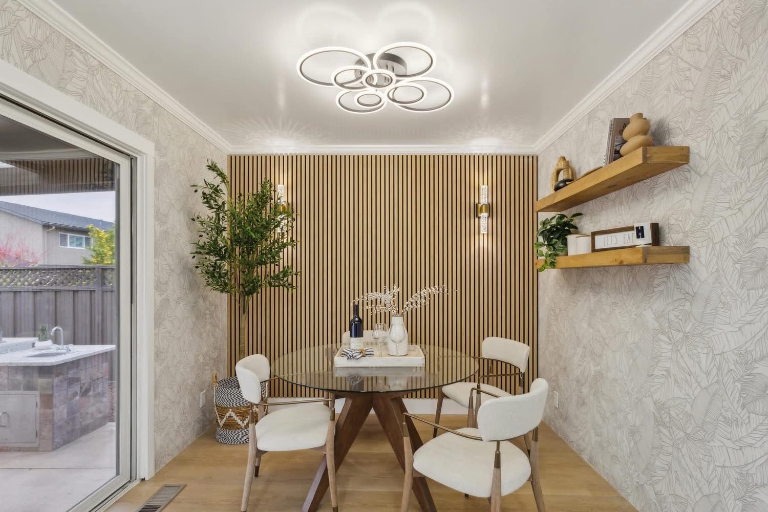 Modern dining room with round table, white chairs, wooden shelves, and striped curtains