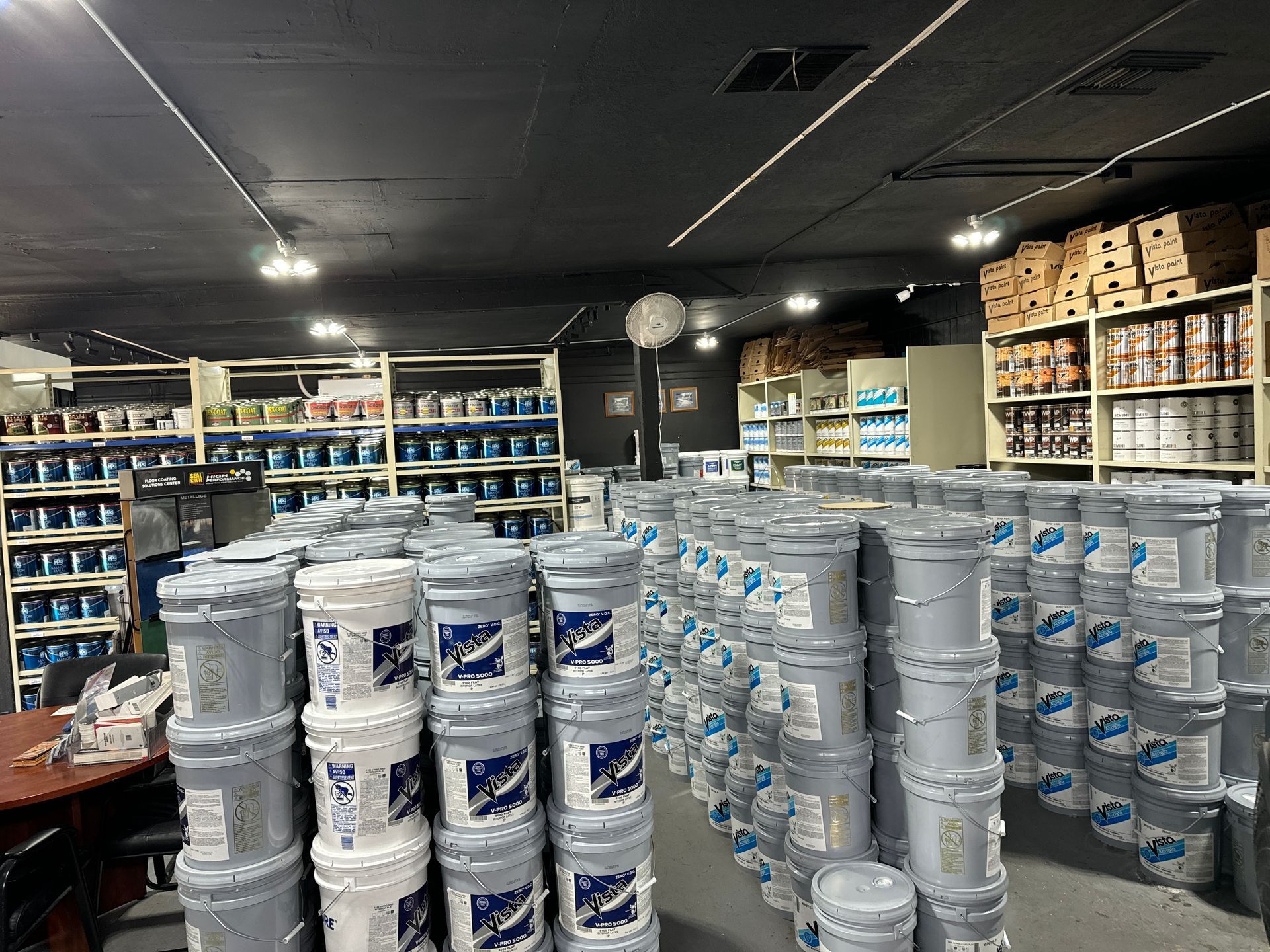 A large warehouse filled with lots of buckets of paint.