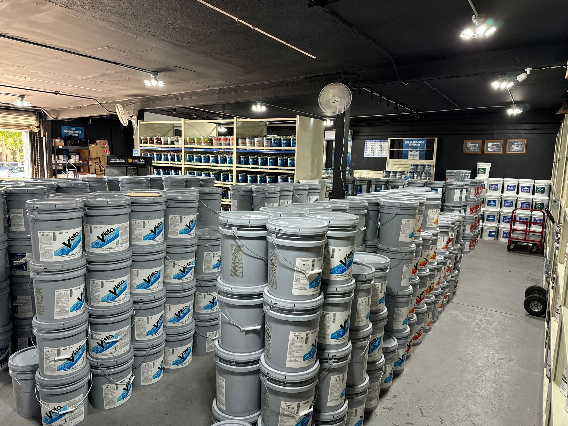 A warehouse filled with lots of buckets of paint.