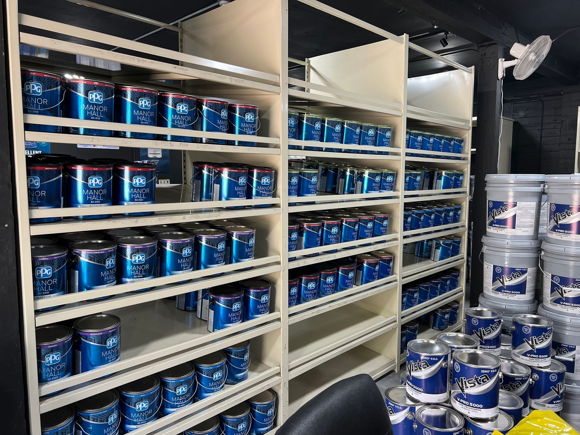 A room filled with shelves filled with buckets of paint.