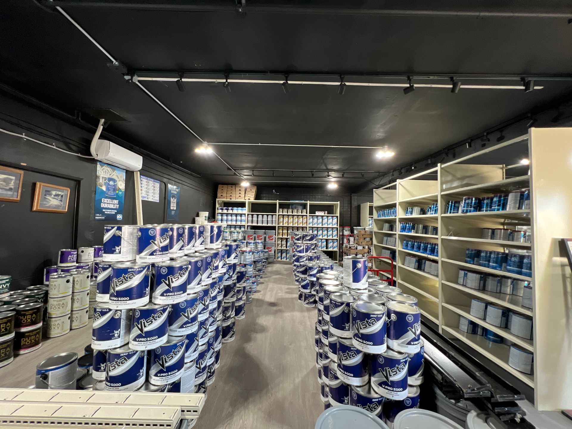 A store filled with lots of buckets of paint and shelves.