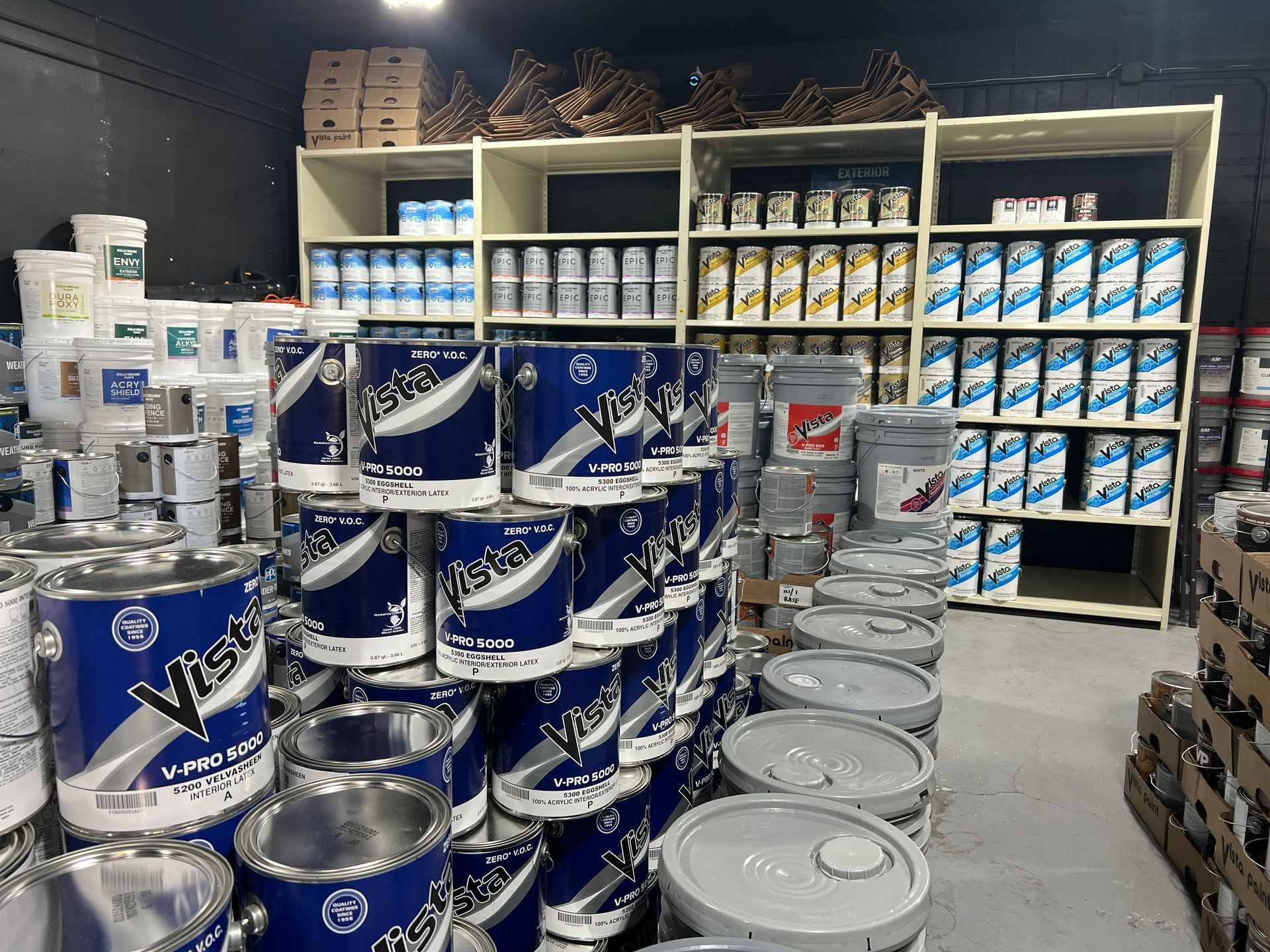 A warehouse filled with lots of buckets of paint.