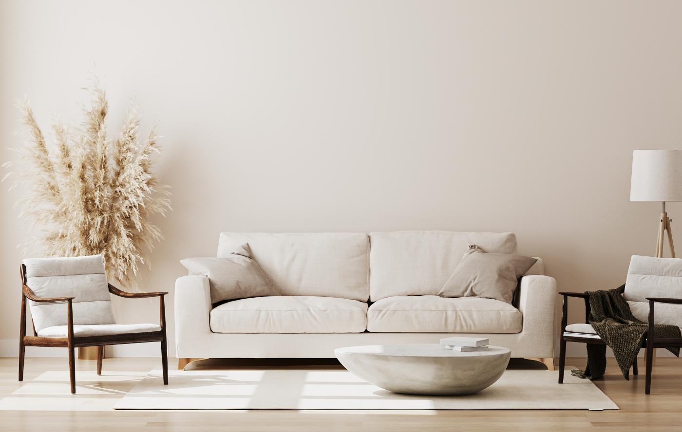 Minimal beige living room with sofa, armchairs, coffee table, floor lamp, and dried grasses.