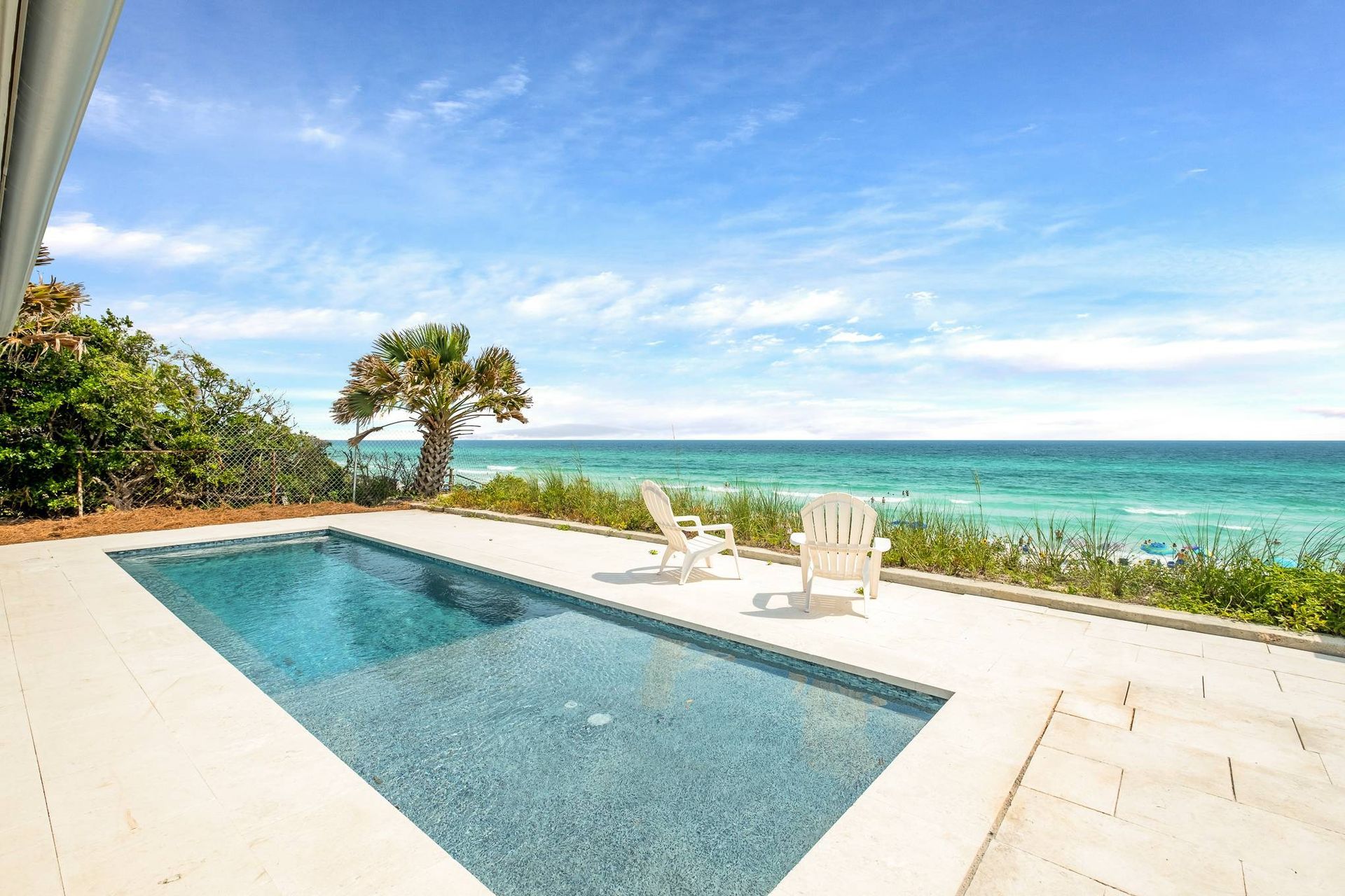 There is a large swimming pool with a view of the ocean.