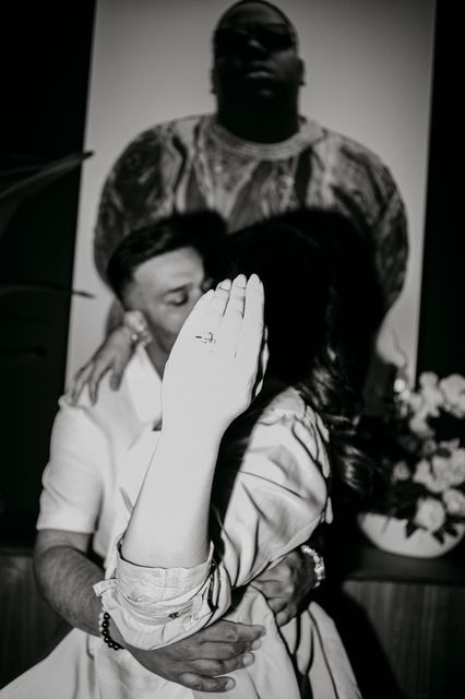 A black and white photo of a man kissing a woman on the cheek.