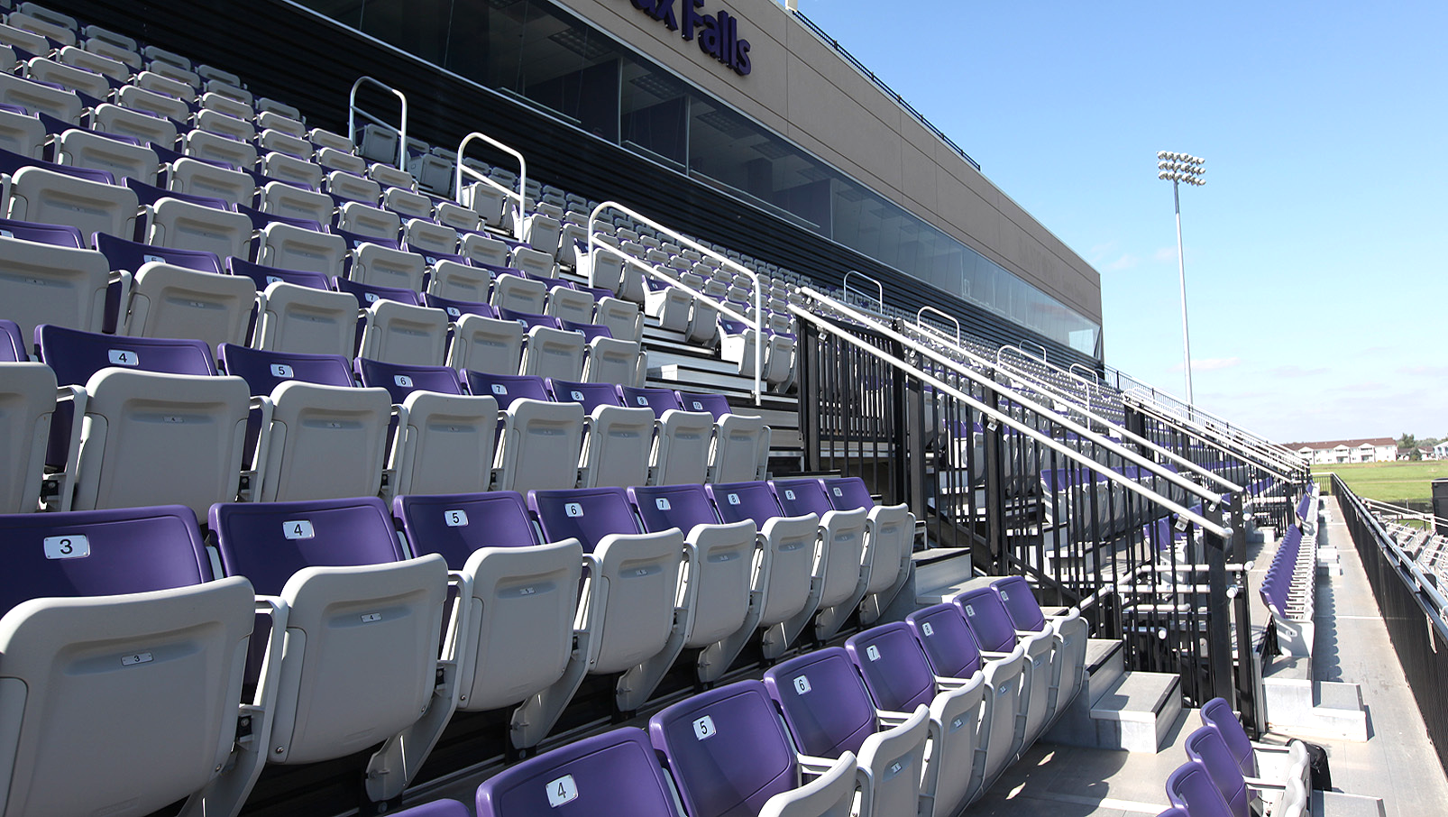 A multi-color use of purple and grey Interkal AURA Solid Stadium Chairs in the stadium at the University of Sioux Falls.