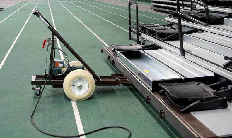 The Interkal Moto-Folder in front of a selection of manual bleachers at the Jenison Fieldhouse at Michigan State University.