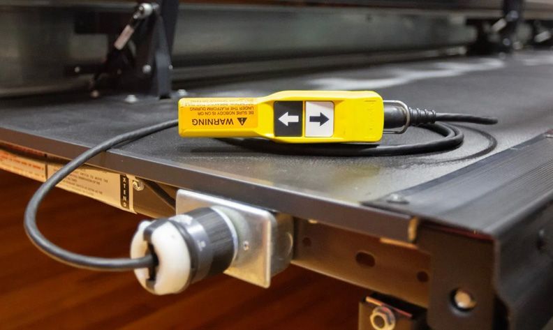 The pendant control for the Interkal telescopic bleachers, shown plugged into the front of the bleacher stack.