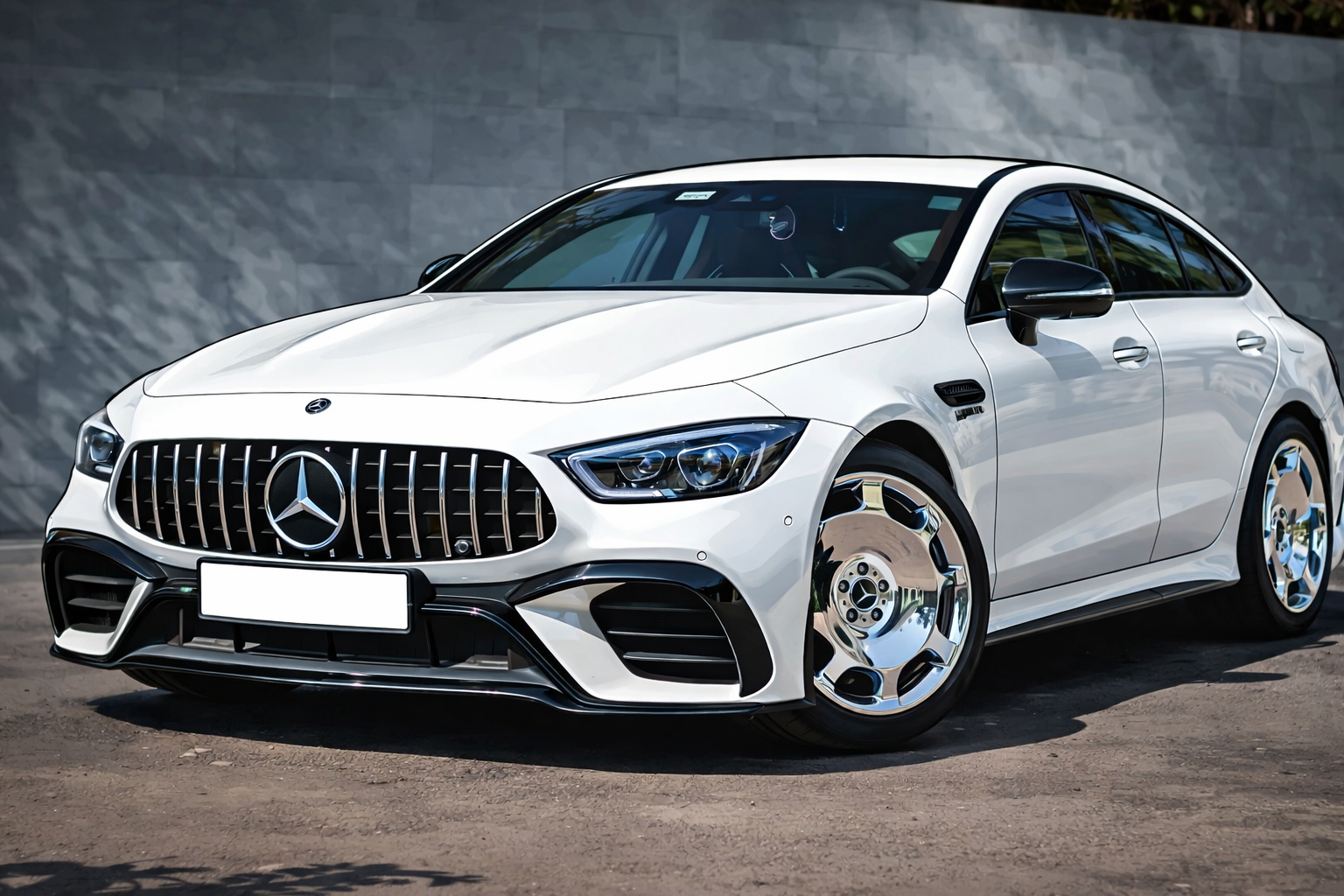 A white Mercedes-AMG GT 4-Door Coupe parked outdoors, featuring a signature vertical slat grille and chrome wheels.