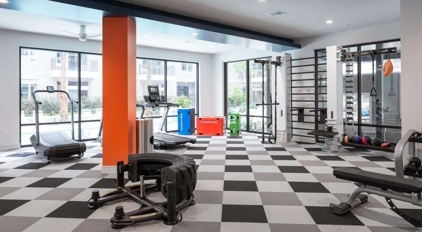 Fitness center with treadmills, weight machines, and plyometric boxes.
