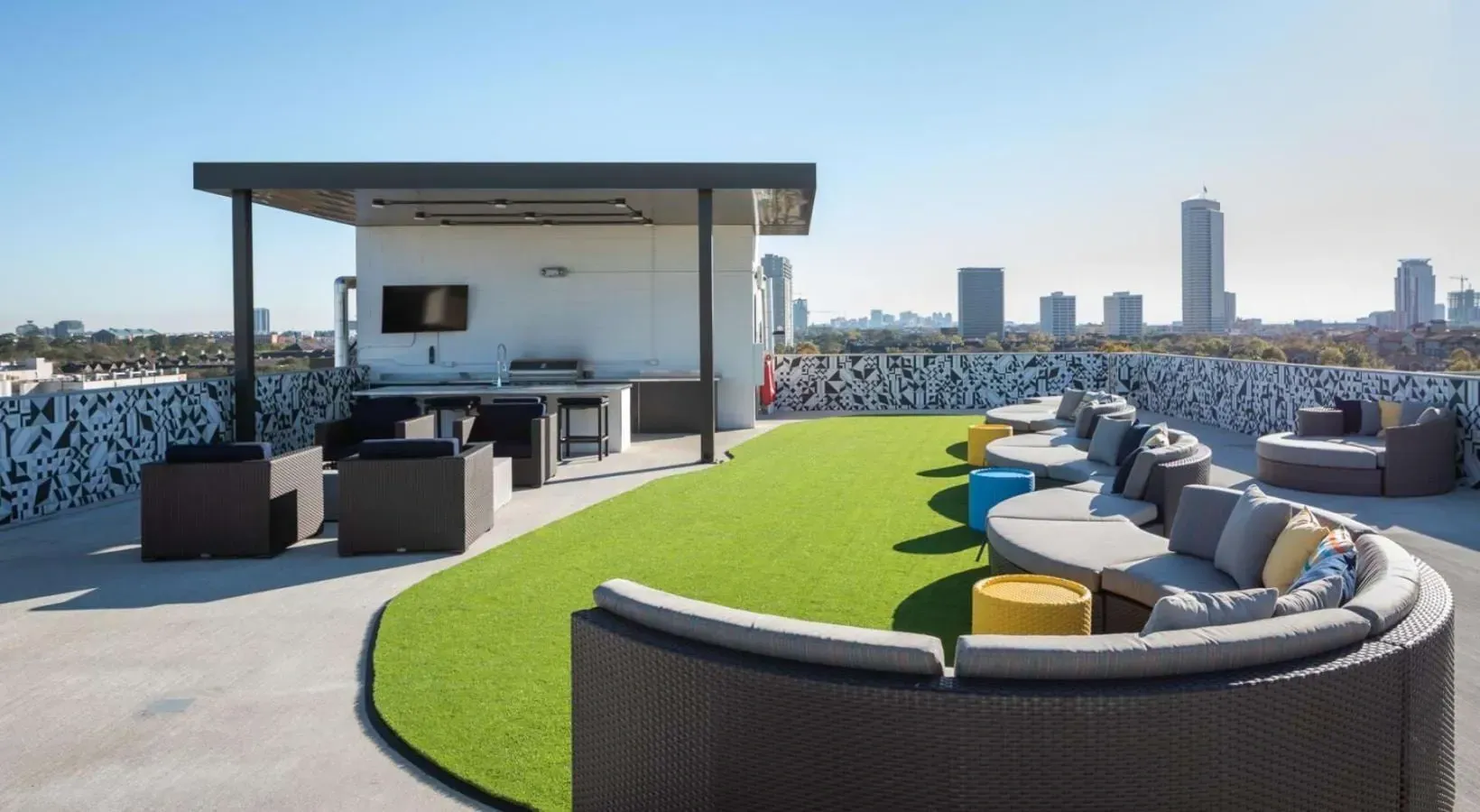 Rooftop lounge area with seating and outdoor kitchen.