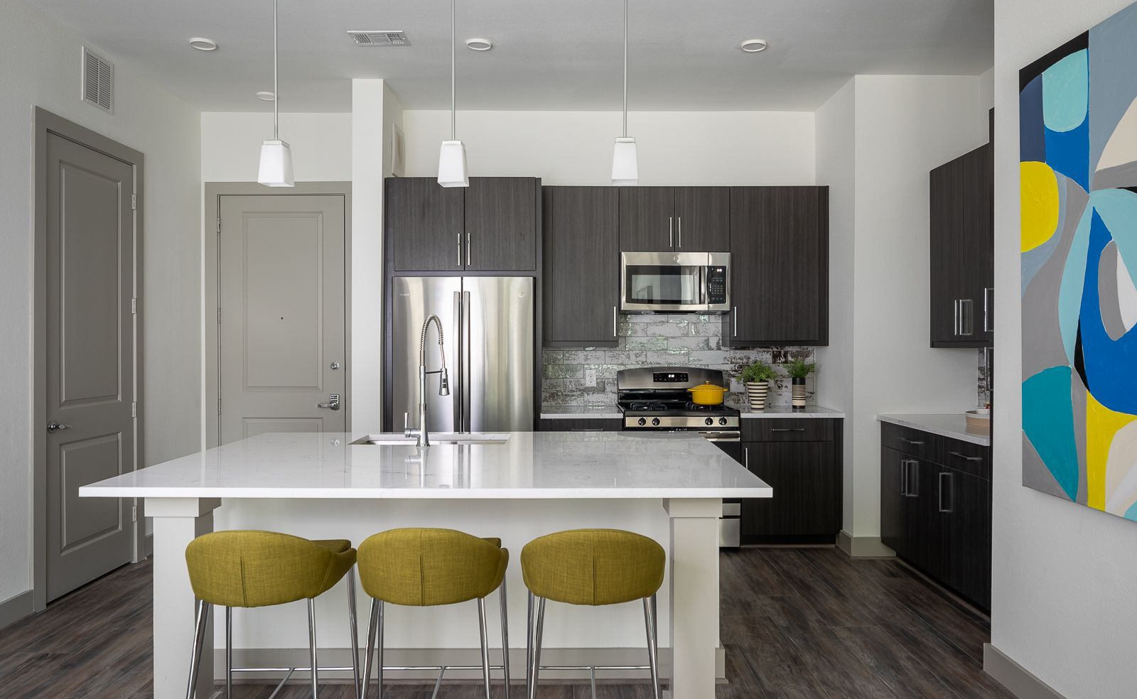 Modern kitchen with island and stainless steel appliances.