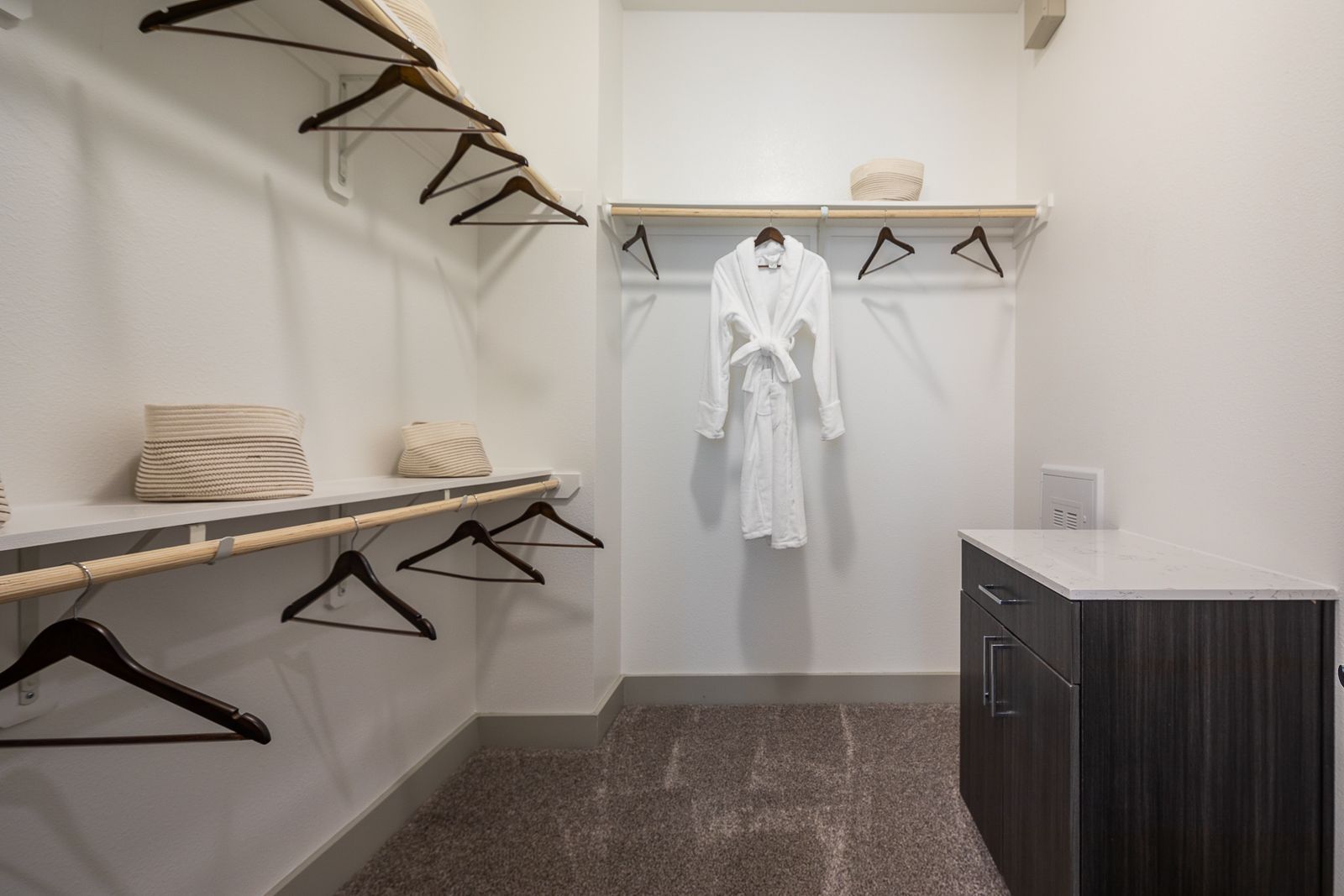 Walk-in closet with built-in shelving, hanging rods, and a robe.