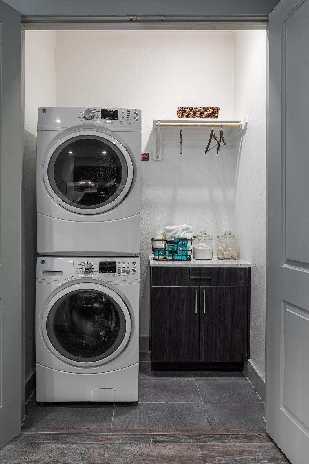 Stackable washer and dryer with laundry supplies.