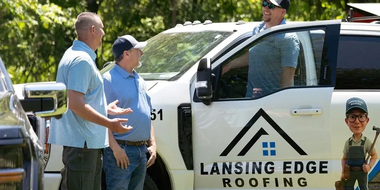 Two men and a boy beside a white Lansing Edge Roofing truck outdoors