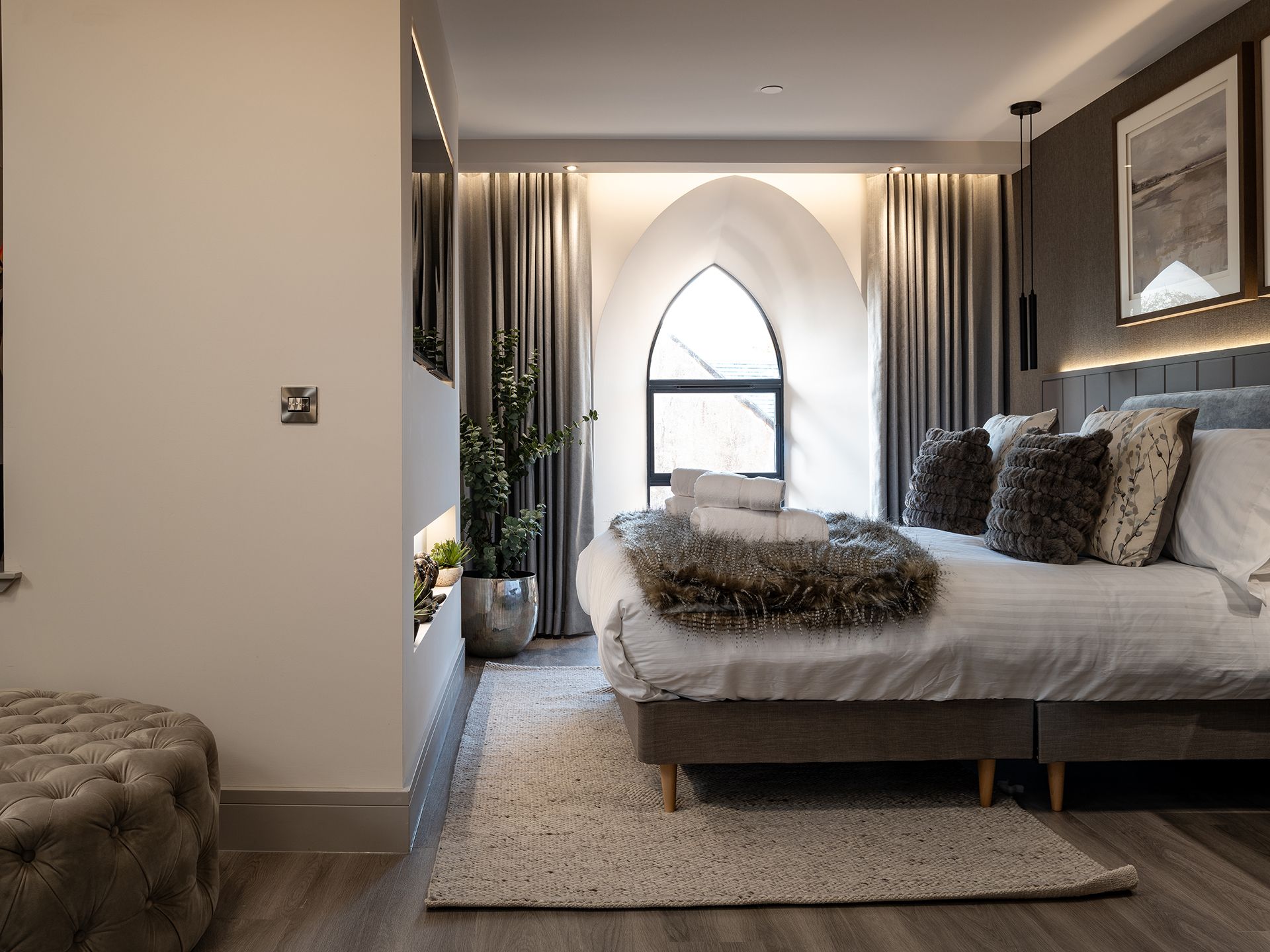 A bedroom with a large bed and a large window.