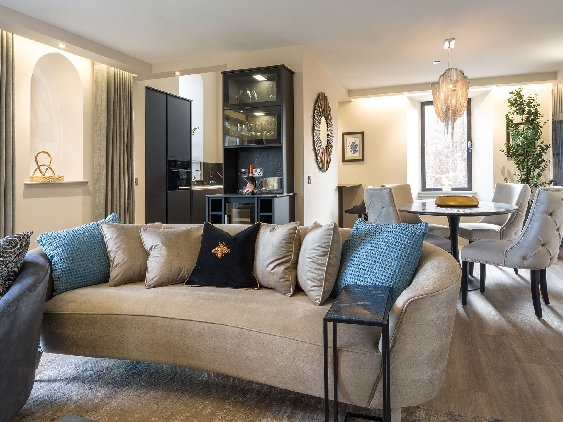 A living room with a curved couch and blue pillows