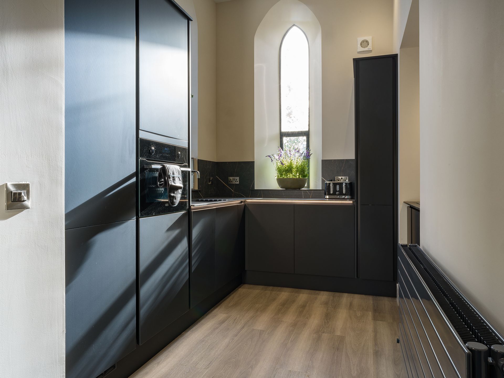 A kitchen with black cabinets and a window