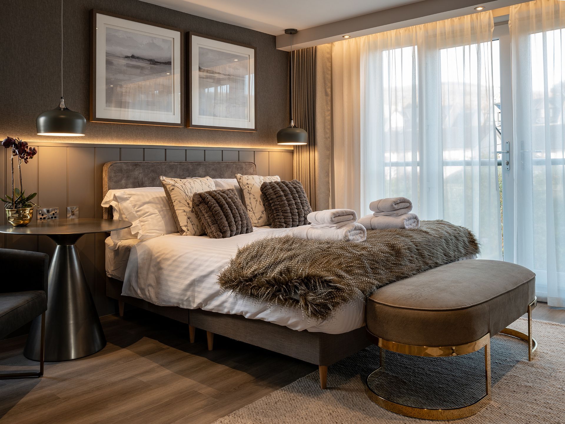 A bedroom with a large bed and a large window.