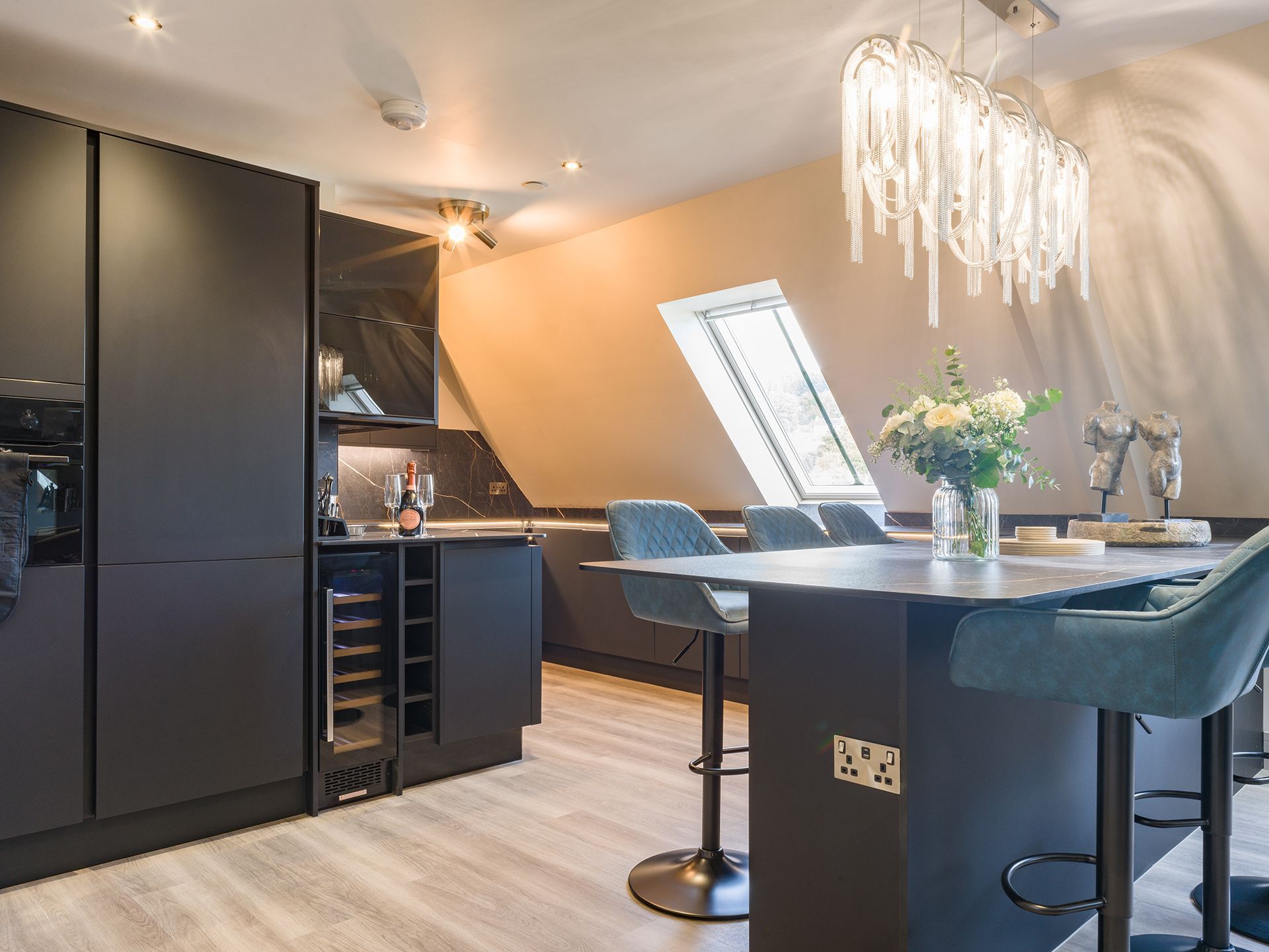 A kitchen with a table and chairs and a chandelier hanging from the ceiling.