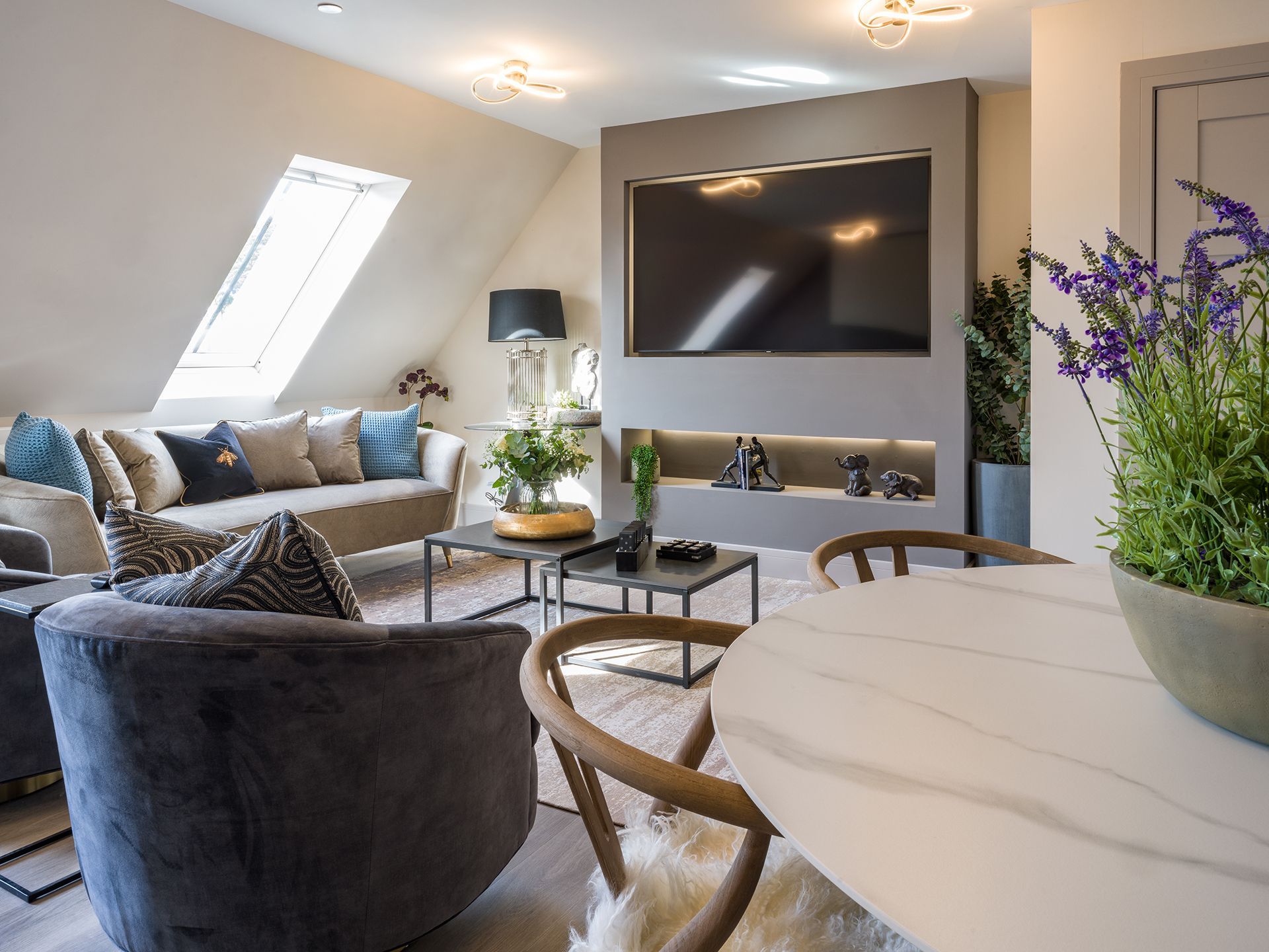 A living room with a couch , chair , table and television.