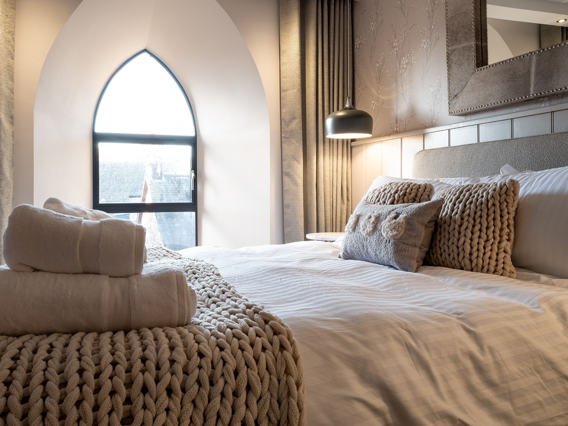 A bedroom with a large bed and a window.