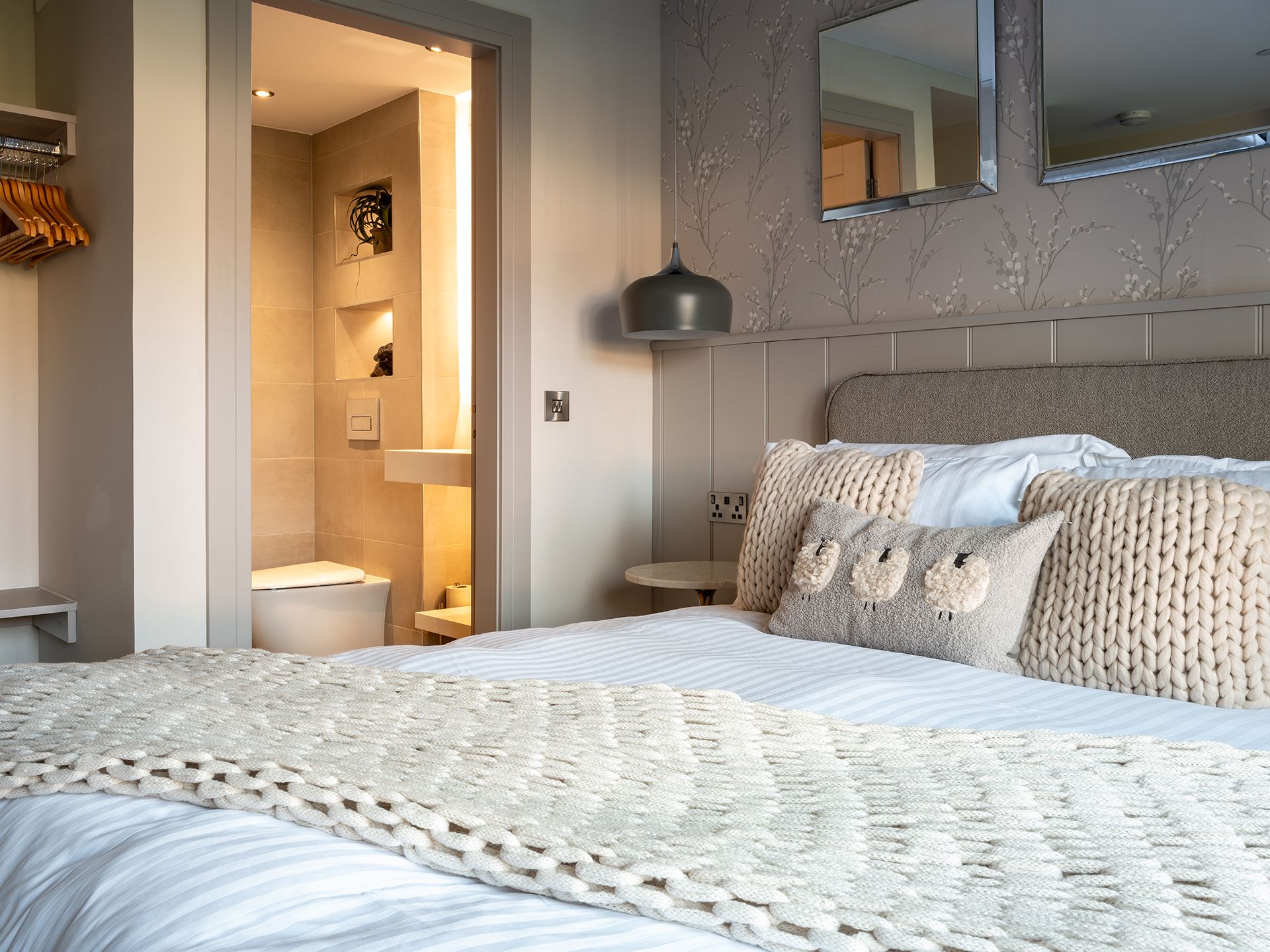 A bedroom with a bed and a bathroom in the background