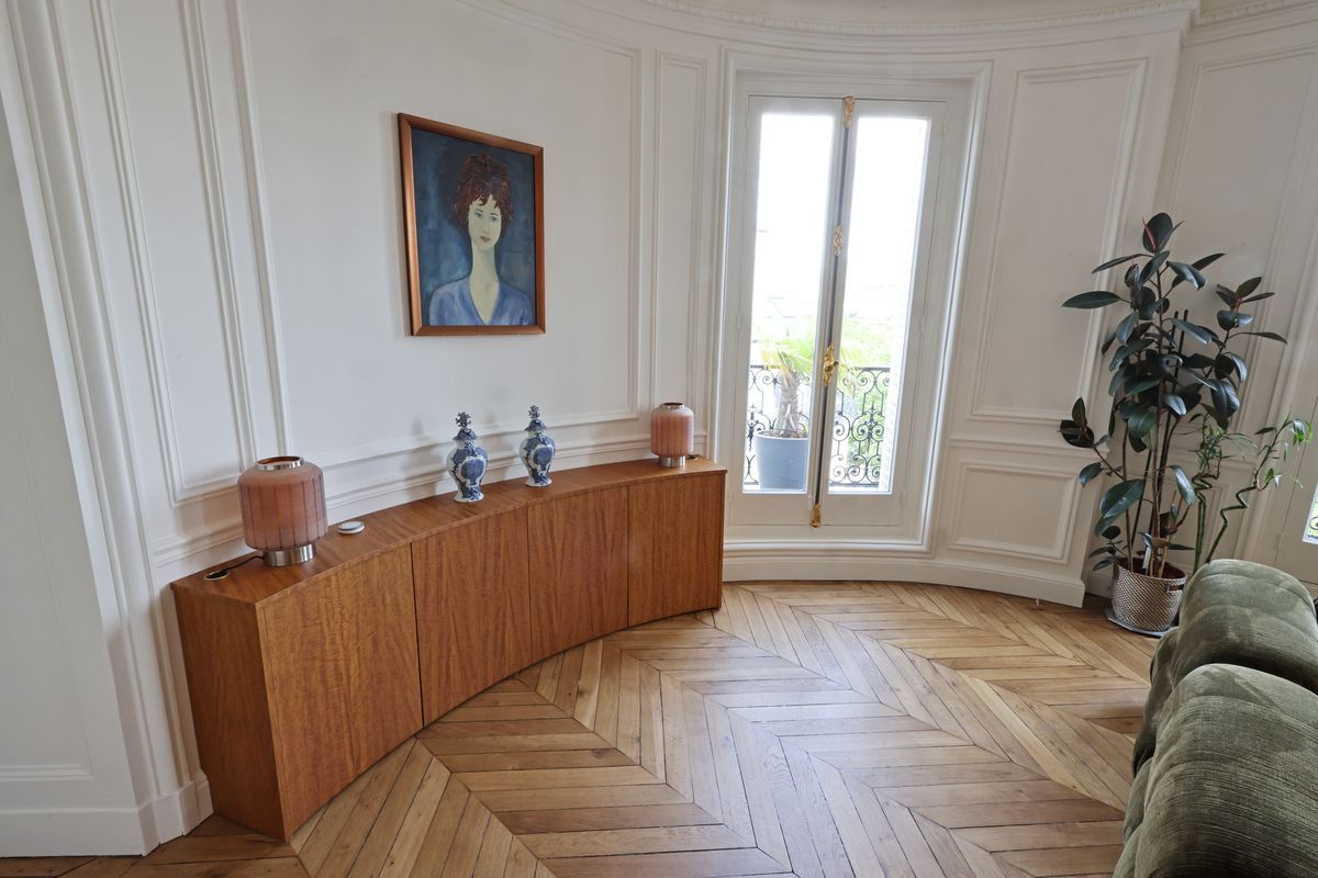 Un plancher en bois avec un motif à chevrons dans un couloir.