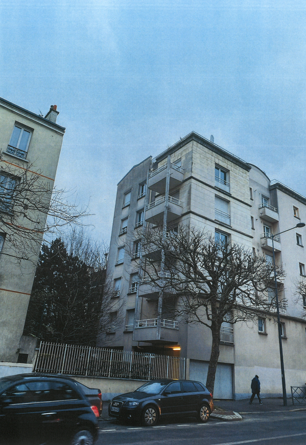 Une voiture est garée devant un grand bâtiment