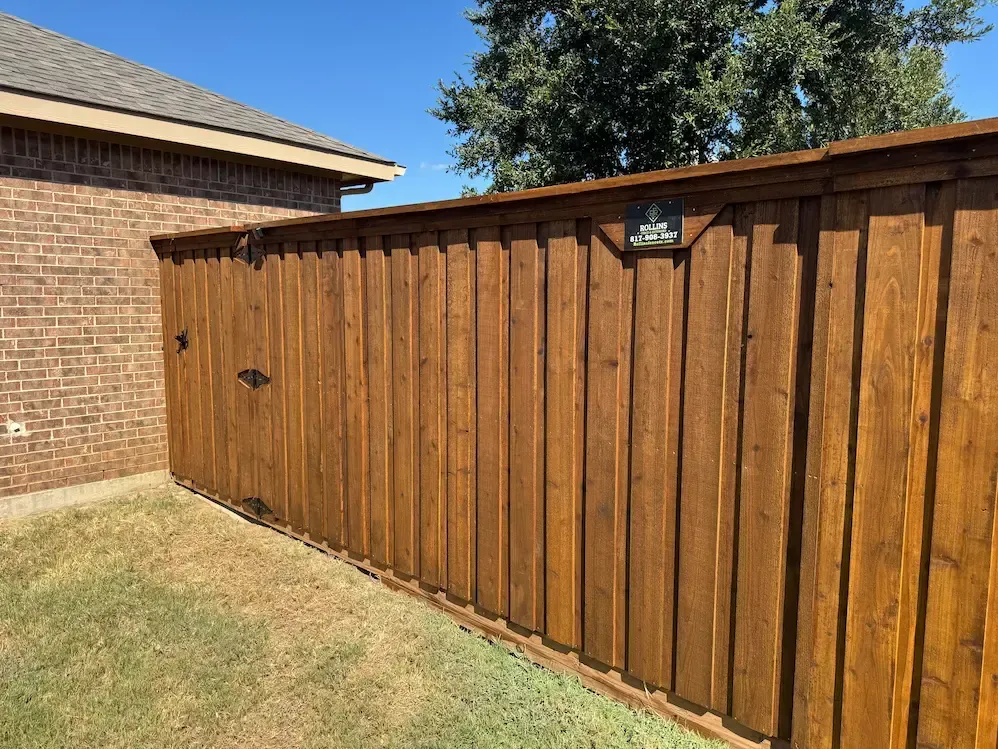 Wood privacy fence with cap and trim and matching gate by Rollins Fence Company in the DFW area.