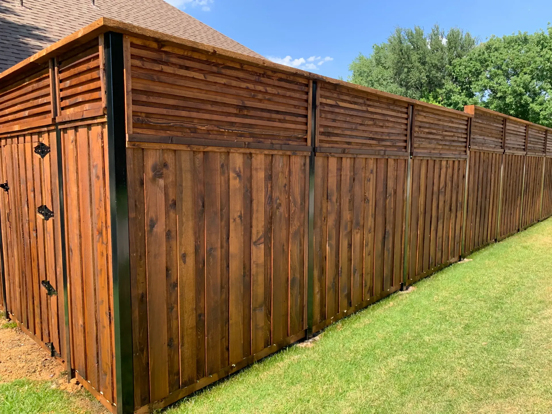 Custom stained wood privacy fence installed by Rollins Fence Company for a residential property in F