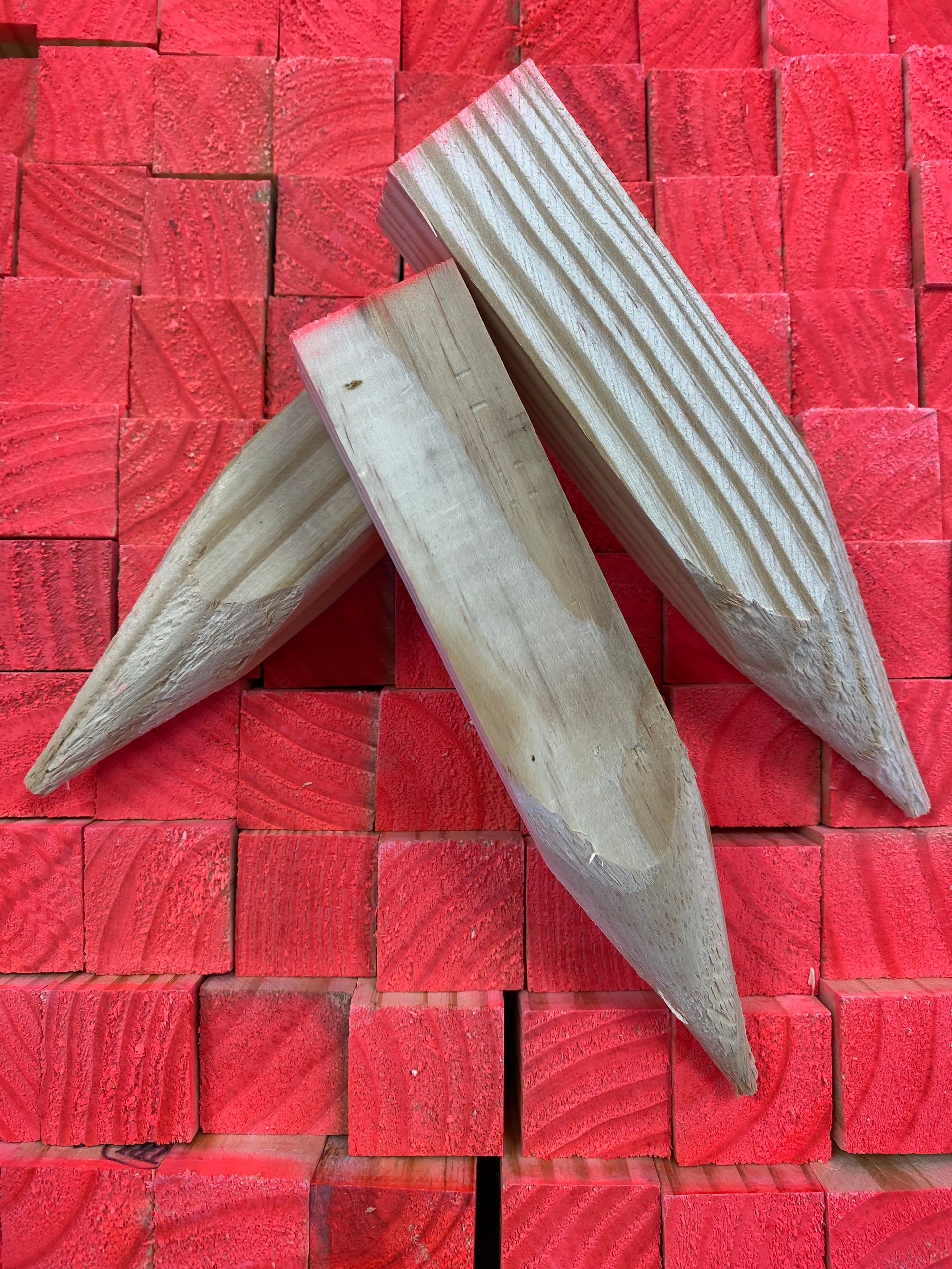 Three wooden seeds on a red woven mat, arranged in a star-like cluster