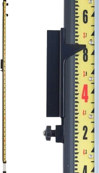Black measuring device mounted beside a yellow ruler on a white background