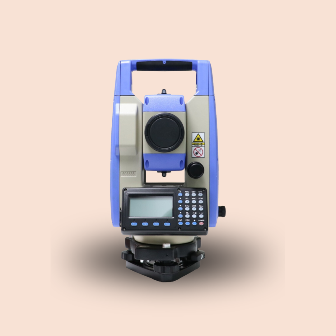 Blue surveying total station on tripod against a plain beige background