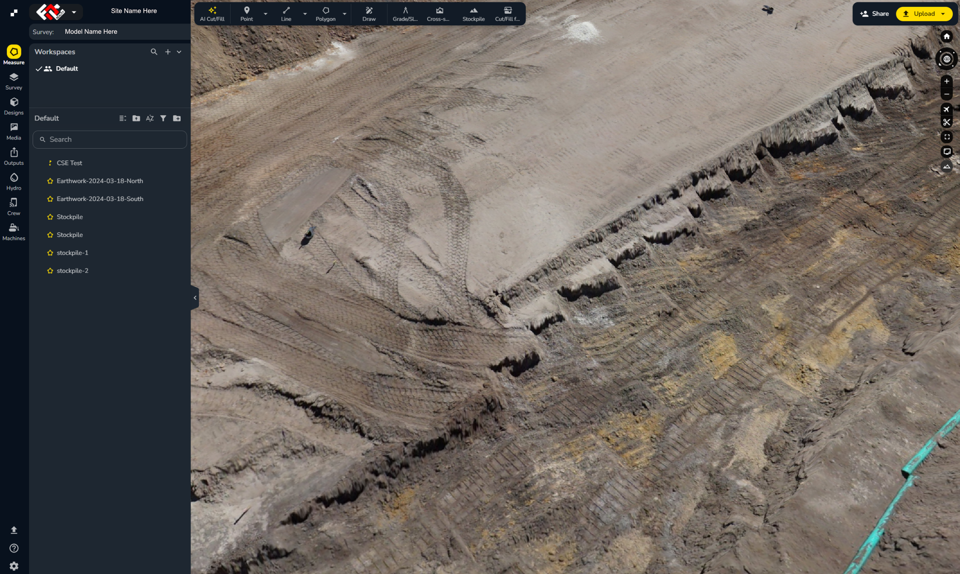 Aerial view of a rocky excavation site with dark trenches and earth-moving tracks in a barren landscape