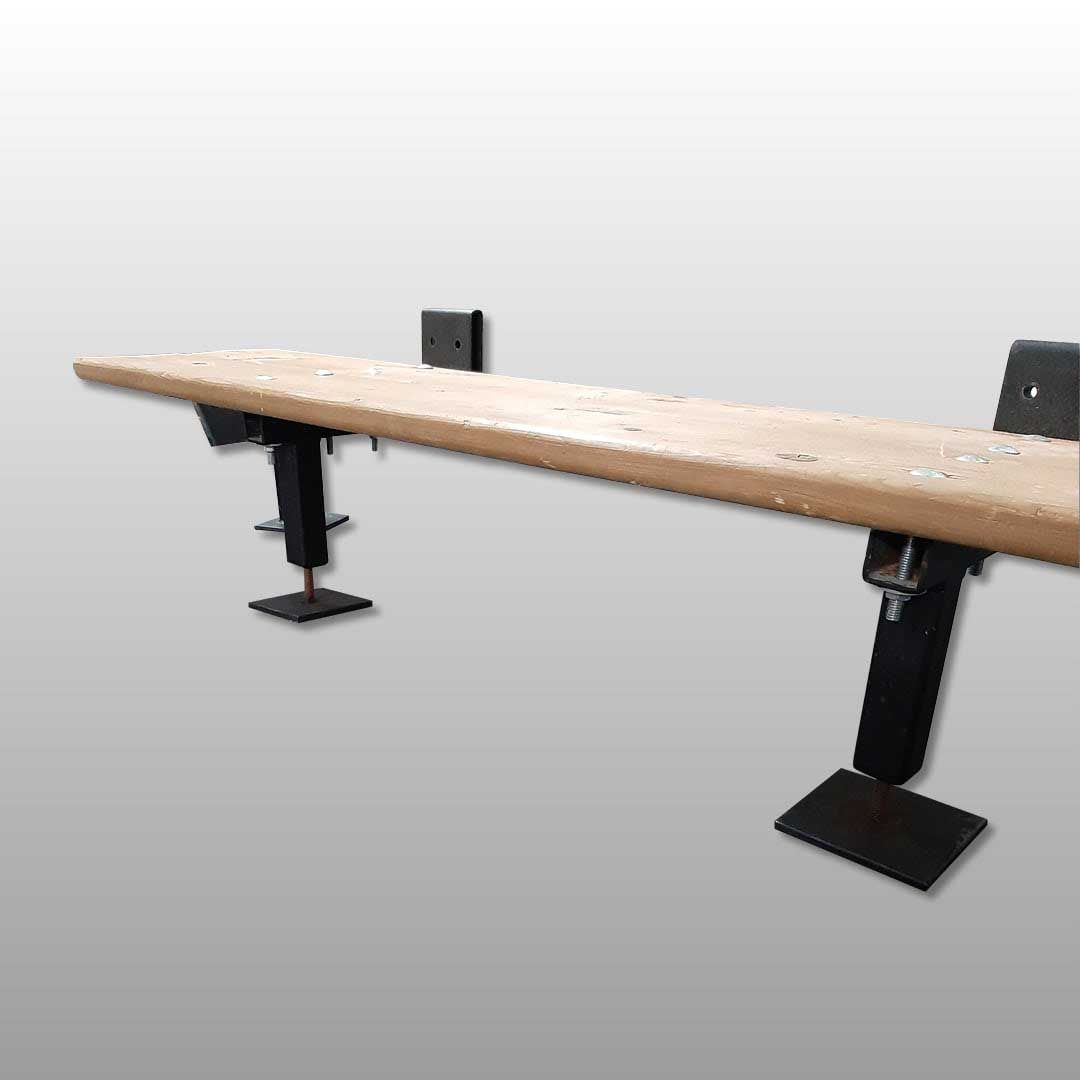 Bureau en bois avec pieds noirs réglables, sur fond gris clair.