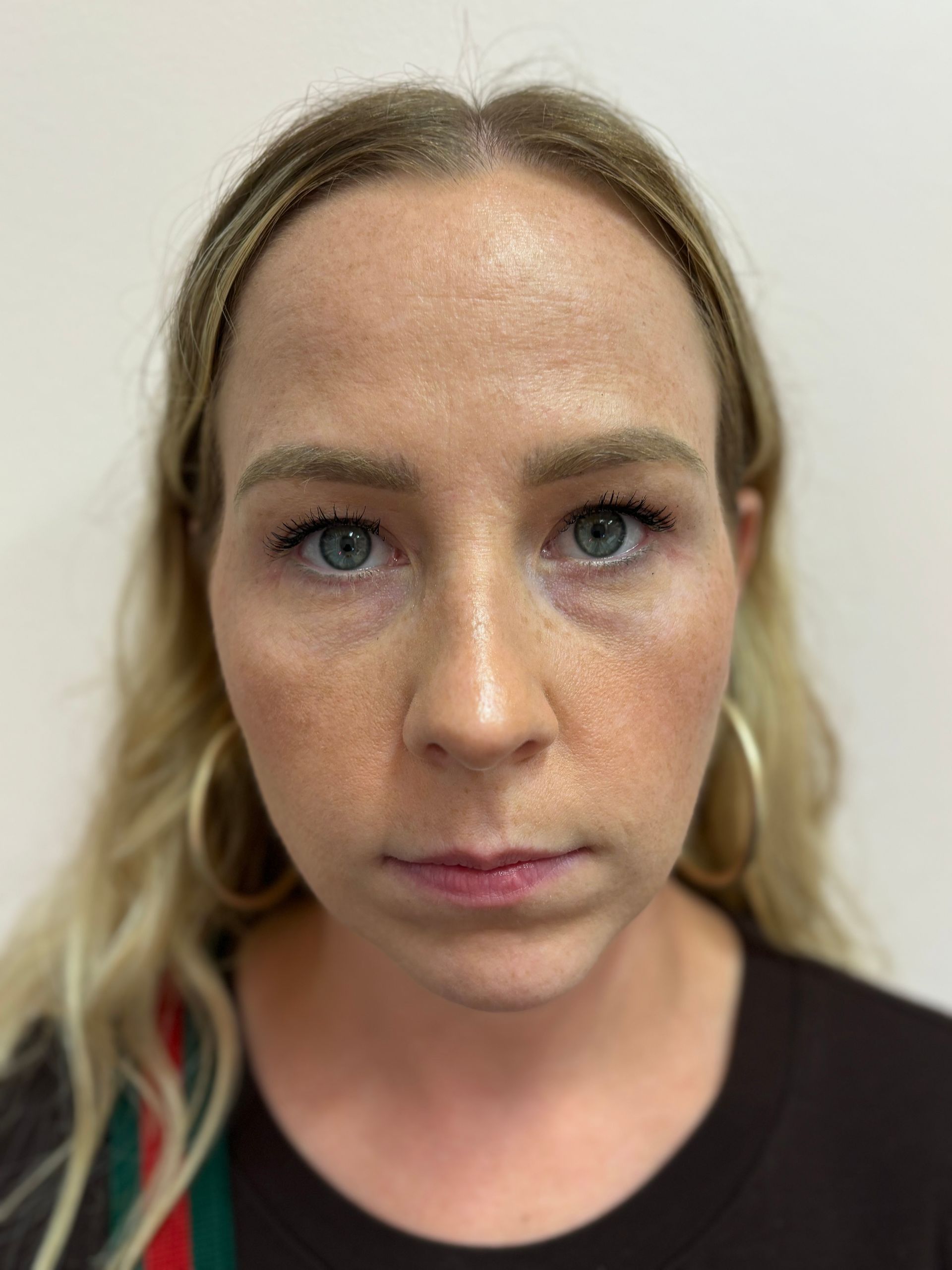 A close up of a woman 's face with a serious look on her face.