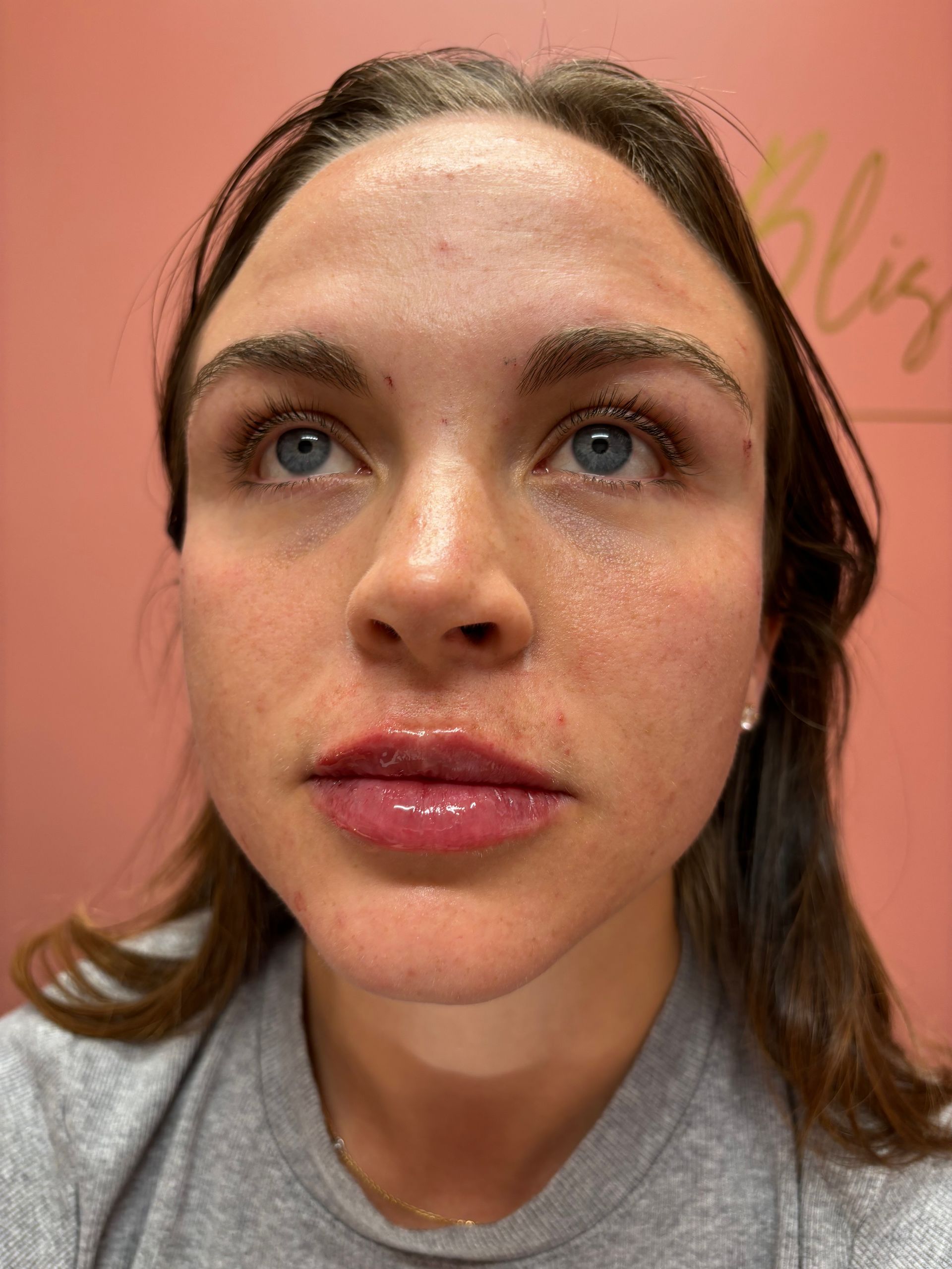 A close up of a woman 's face with a pink background
