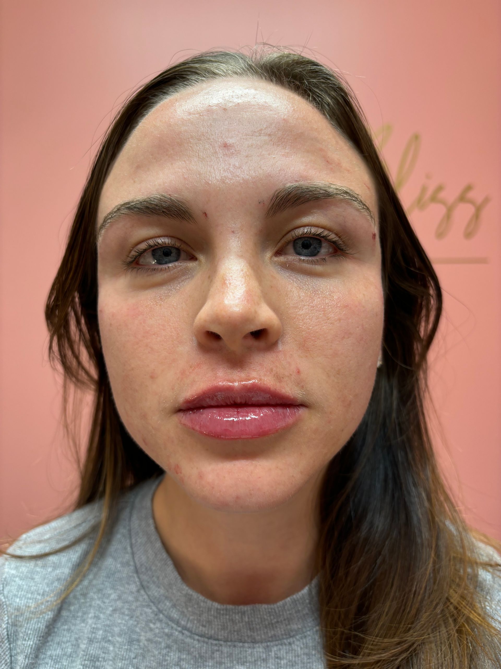 A close up of a woman 's face with a pink background.