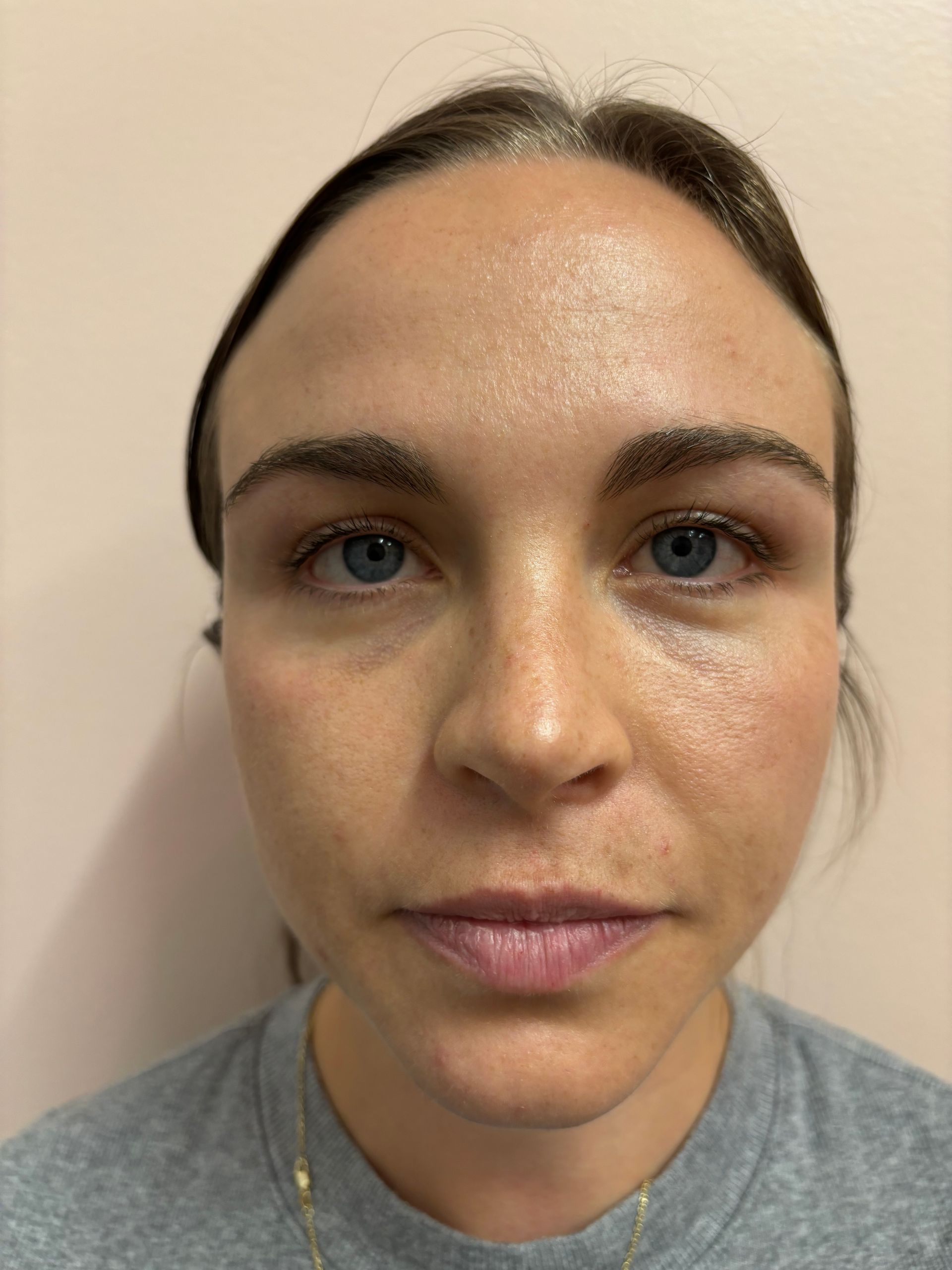 A close up of a woman 's face with a gray shirt on.