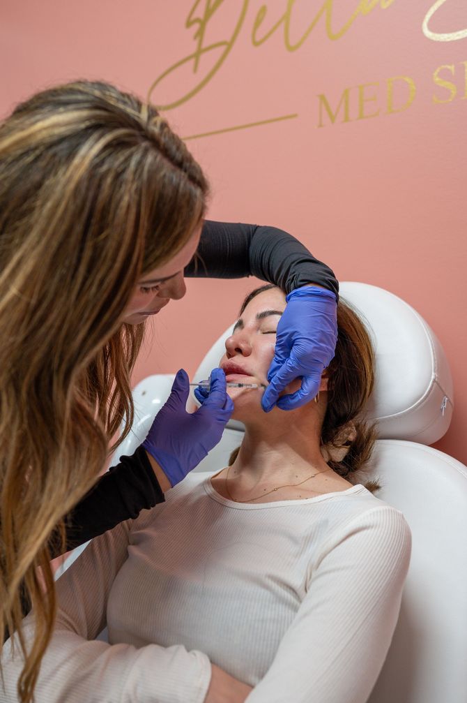 A woman is getting a botox injection in her face.