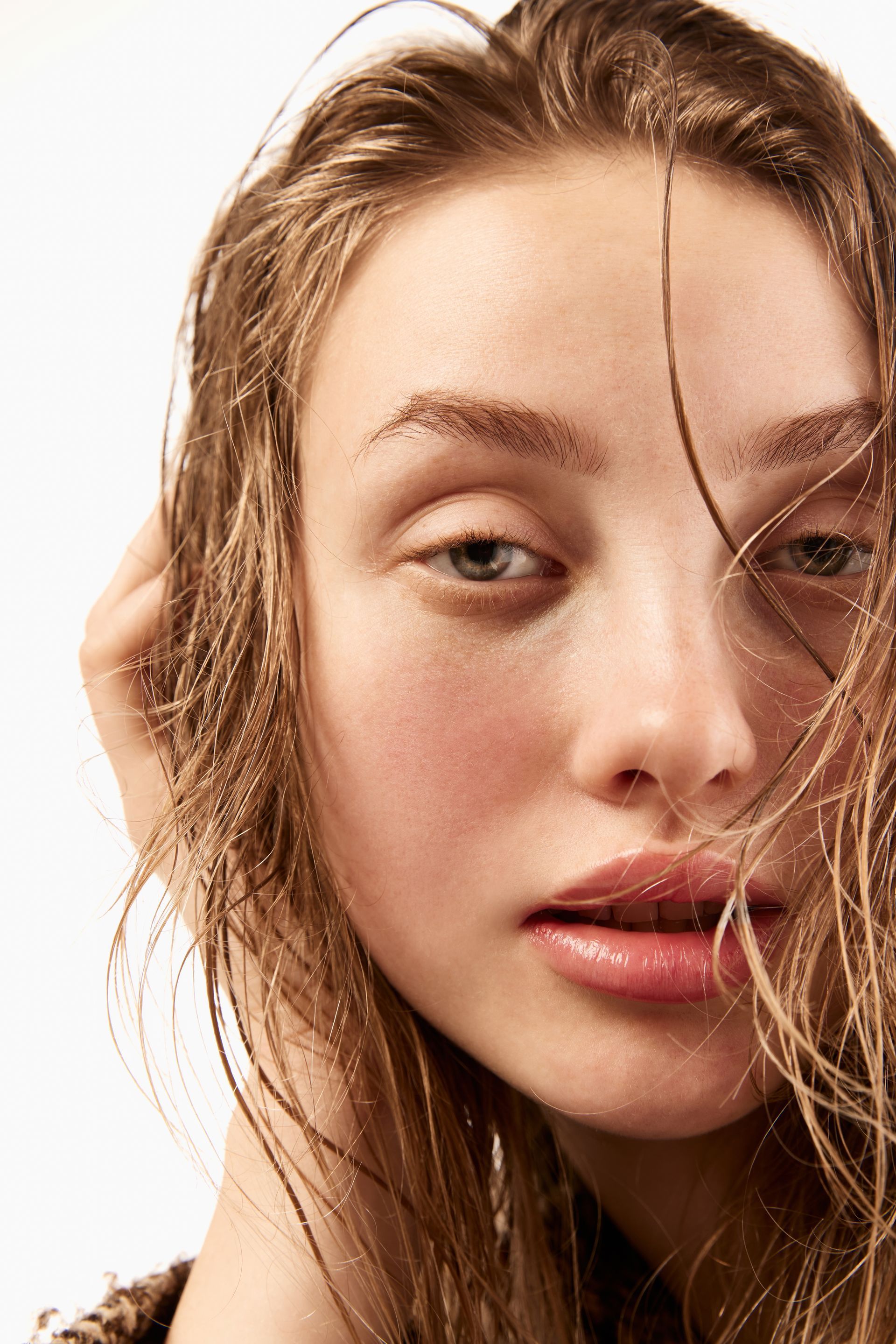 A close up of a woman 's face with wet hair