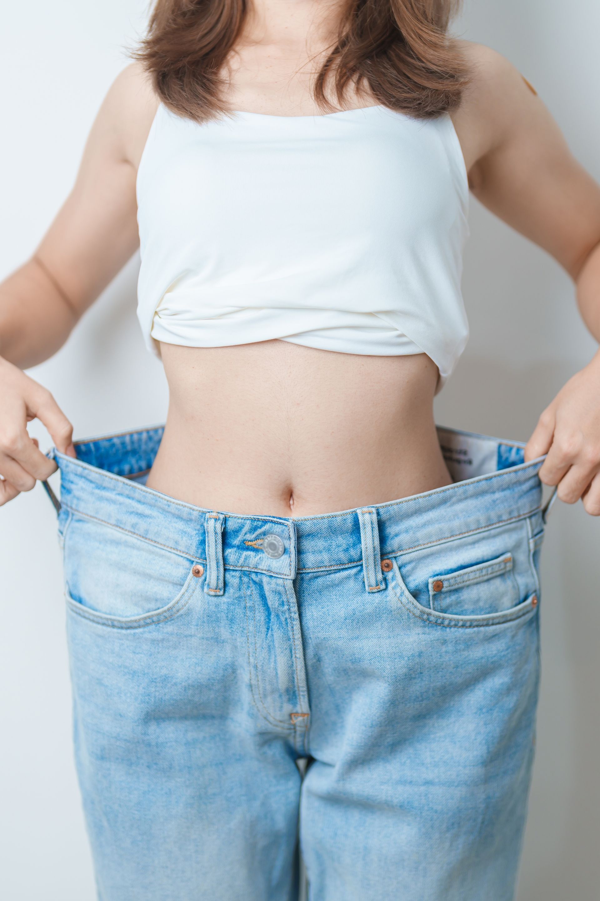 A woman is wearing a pair of very large jeans.